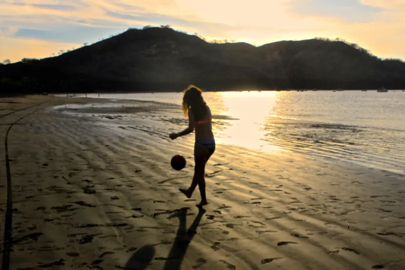 Meisje met voetbal op het strand in Costa Rica