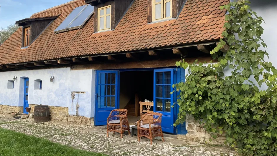 Hotels Roemenië - huisje met open deuren en stoelen.